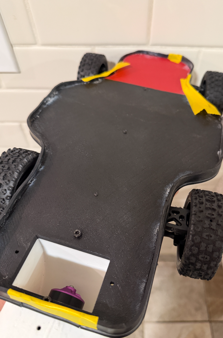 Underside of the RC fan car showing the sealed vacuum tray