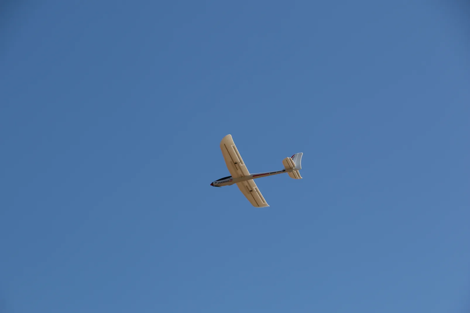 The glider in flight against blue sky